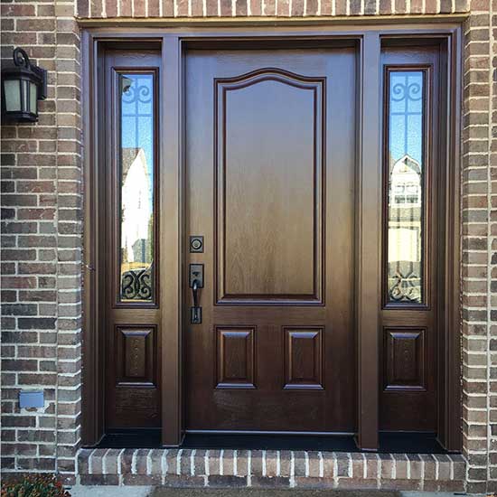 Sophisticated entrance to a brick house with HXHome Solutions' dark wood door and sleek black hardware, adding a touch of elegance and modernity to the exterior.